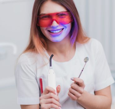 beautiful-girl-orthodontist-posing-with-instruments-clinic-scaled